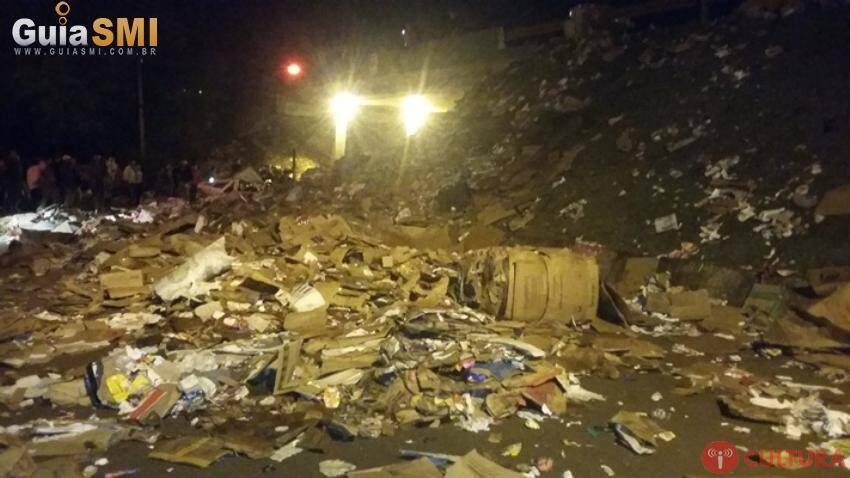 Caminhão tomba e carga cai em cima de veículo