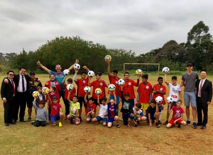 Meninos que treinam futebol em campinhos de bairro ganham bolas novas para treinar no contraturno escolar