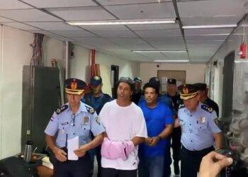 Ronaldinho e irmão chegam algemados para depor no Paraguai; vídeo