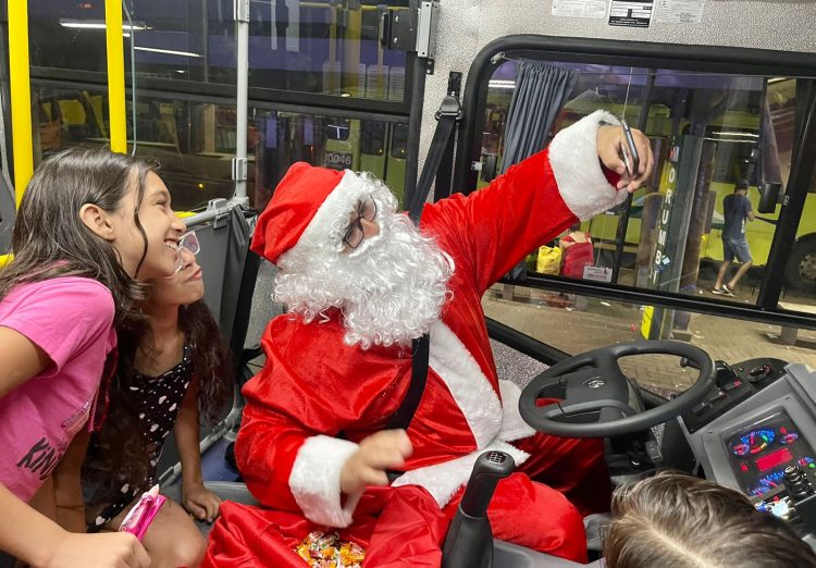 Ônibus iluminado e dirigido por Papai Noel está encantando adultos e crianças