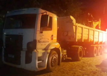 Caminhão carregado com retroescavadeira foge de perseguição da PM e passa a ponte